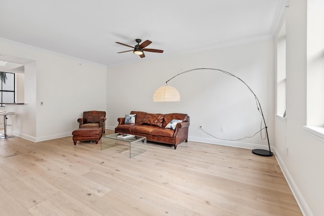 living room featuring ceiling fan, light hardwood / wood-style flooring, and crown molding