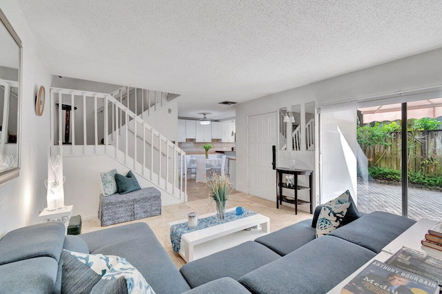 living room with ceiling fan and a textured ceiling