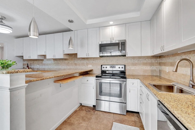 kitchen featuring stainless steel appliances, backsplash, sink, pendant lighting, and white cabinetry