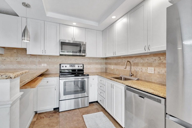 kitchen with white cabinetry, stainless steel appliances, sink, and hanging light fixtures