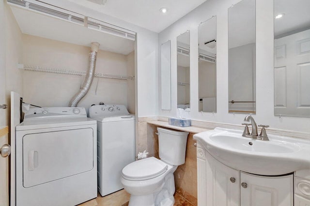 bathroom with vanity, washer and clothes dryer, toilet, and tile patterned flooring