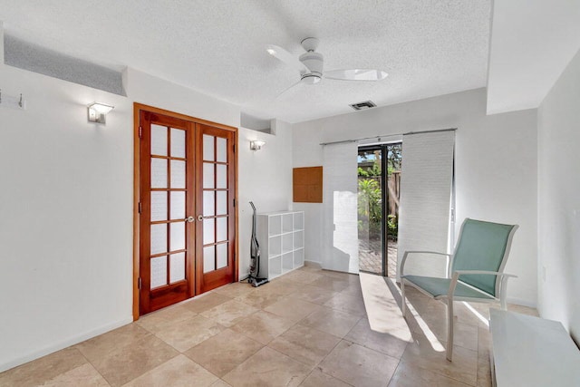 unfurnished room featuring french doors, a textured ceiling, and ceiling fan