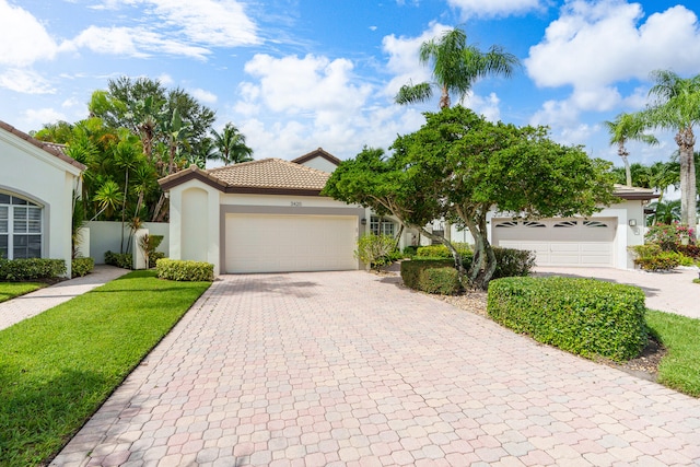 view of front of property with a front yard and a garage