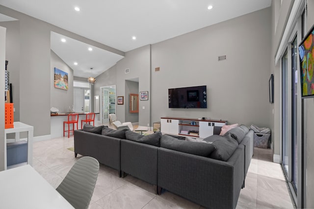 living room with high vaulted ceiling and an inviting chandelier