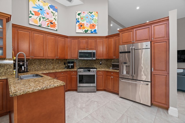 kitchen with sink, backsplash, light stone counters, high vaulted ceiling, and high end appliances