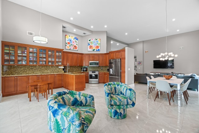 kitchen with decorative backsplash, high vaulted ceiling, sink, decorative light fixtures, and stainless steel appliances