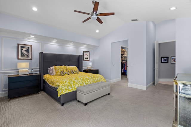 carpeted bedroom featuring a closet, lofted ceiling, ceiling fan, and a walk in closet