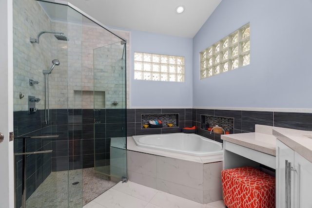 bathroom featuring vanity, independent shower and bath, and lofted ceiling