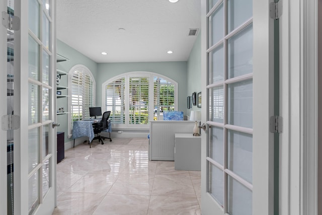 office space with french doors and a textured ceiling