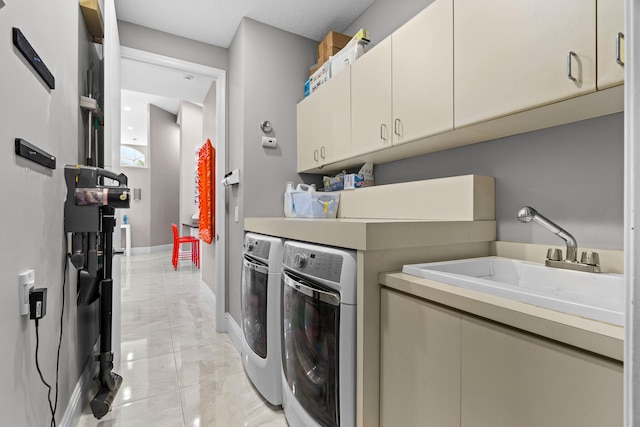 laundry room featuring cabinets, sink, washing machine and clothes dryer, and light tile patterned floors