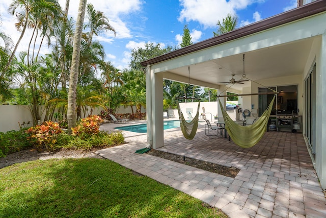 view of patio / terrace with a fenced in pool and ceiling fan