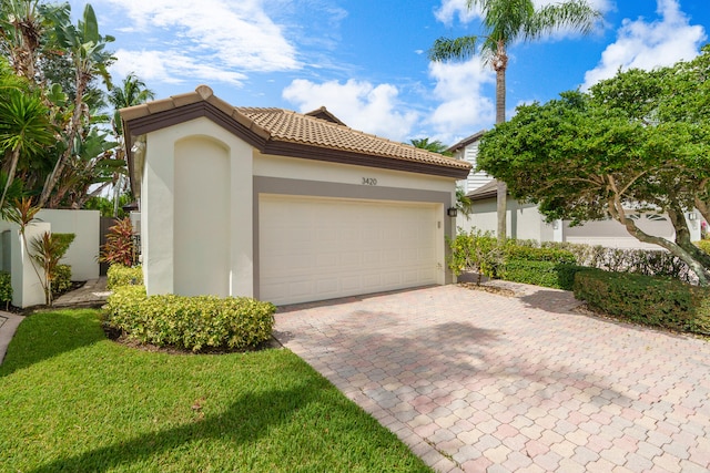 mediterranean / spanish home featuring a front lawn and a garage