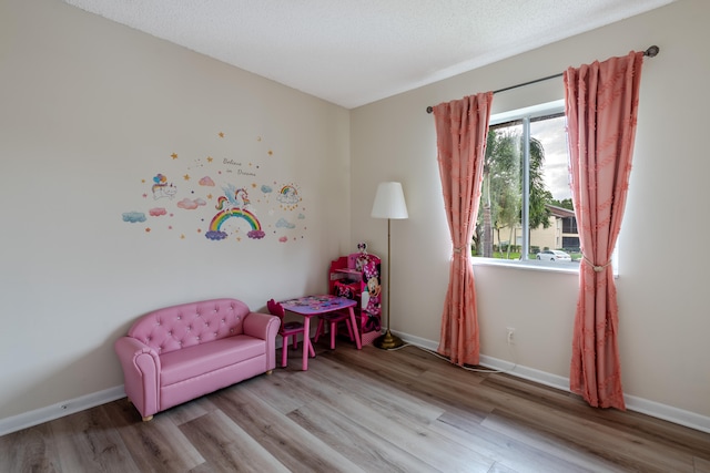 sitting room featuring a textured ceiling and light hardwood / wood-style flooring