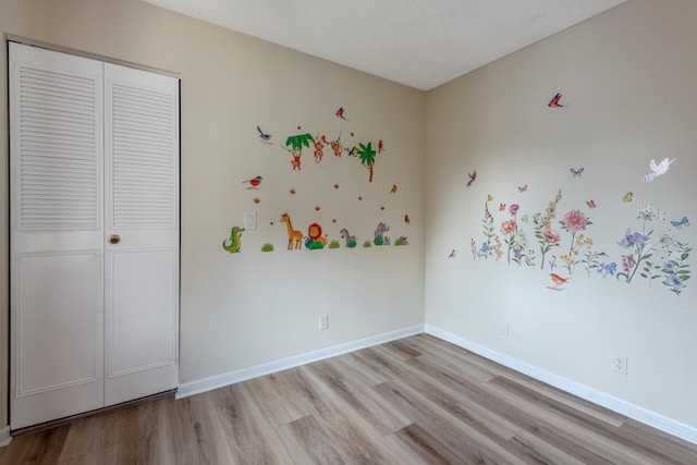 unfurnished bedroom featuring light wood-type flooring and a textured ceiling