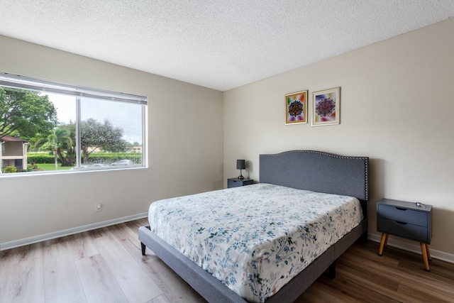 bedroom with hardwood / wood-style flooring and a textured ceiling