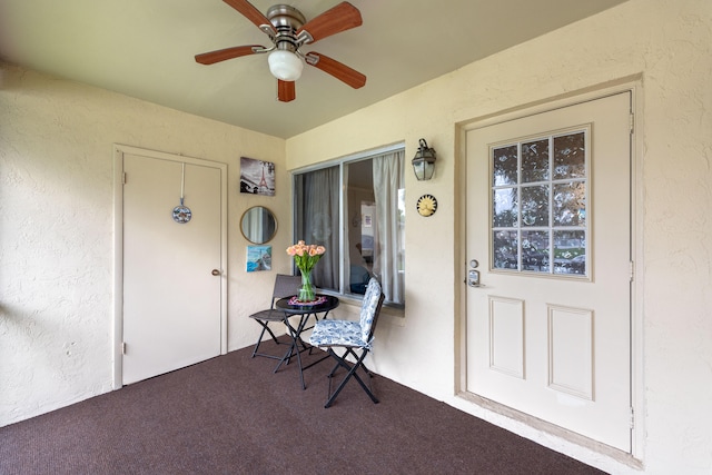 view of exterior entry featuring ceiling fan