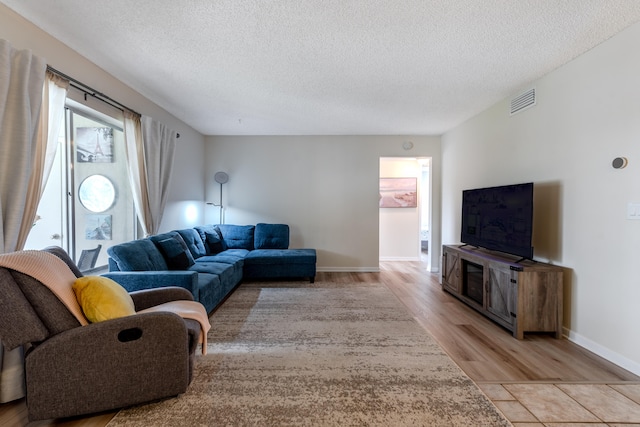 living room with light wood-type flooring and a textured ceiling