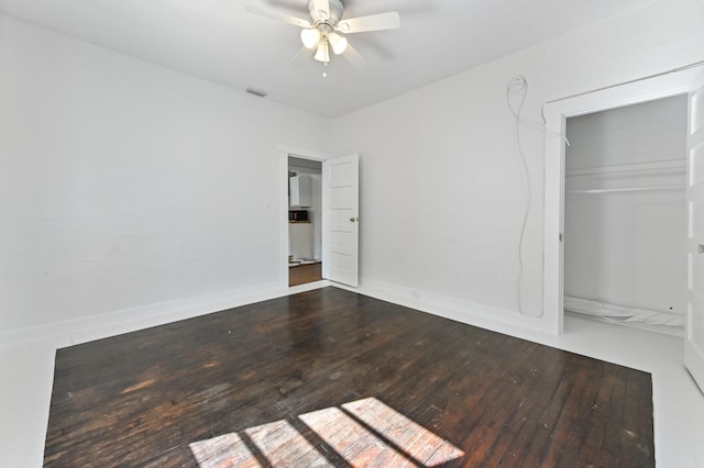 unfurnished bedroom with ceiling fan, a closet, and hardwood / wood-style floors