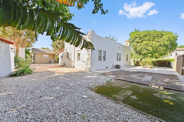 back of property with a patio area and central AC