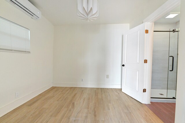 spare room featuring light wood-type flooring and a wall mounted AC