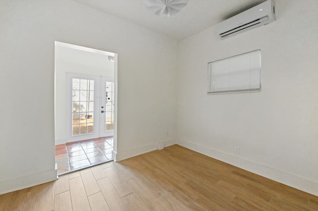 unfurnished room with light wood-type flooring and a wall mounted AC