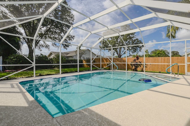 view of swimming pool featuring glass enclosure and a patio