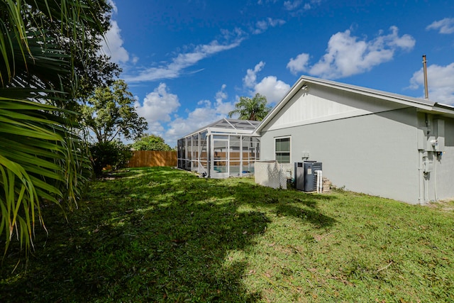 back of property with a lanai, cooling unit, a yard, and a pool