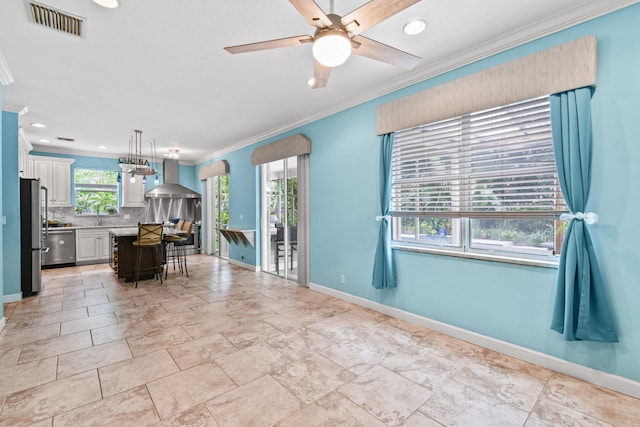 interior space featuring decorative backsplash, a center island, a breakfast bar, white cabinets, and wall chimney range hood