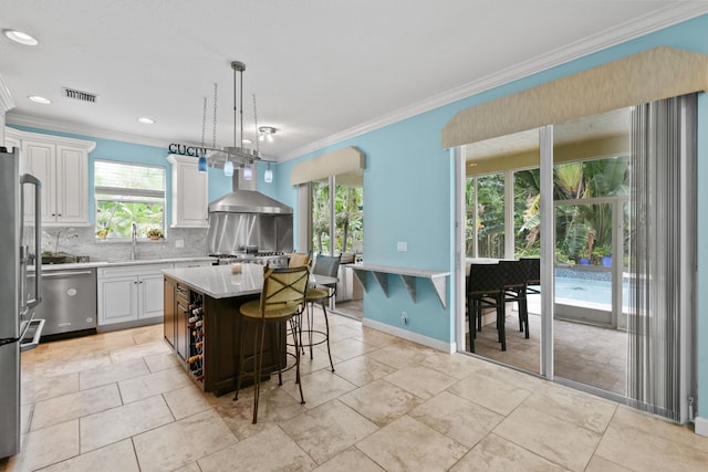 kitchen with pendant lighting, dishwasher, white cabinetry, and a center island