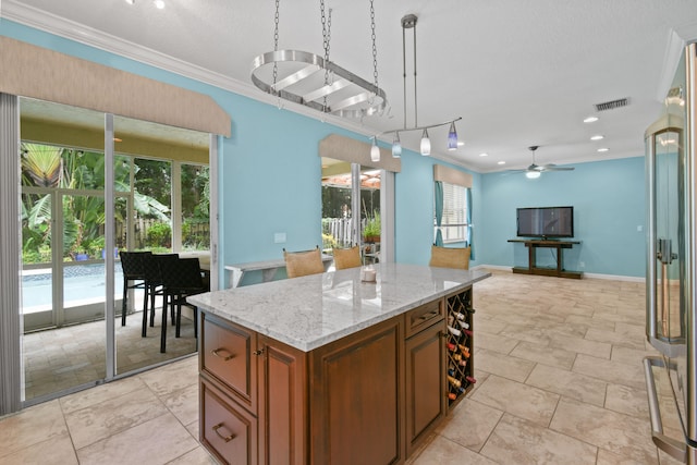 kitchen featuring decorative light fixtures, plenty of natural light, and ornamental molding