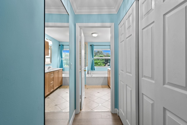 corridor with ornamental molding, sink, and light tile patterned flooring