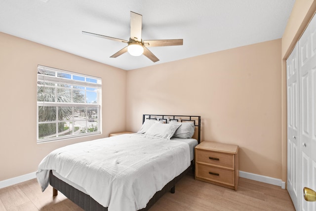 bedroom featuring a closet, light hardwood / wood-style floors, and ceiling fan