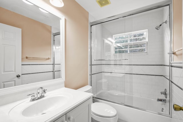 full bathroom featuring vanity, toilet, and combined bath / shower with glass door