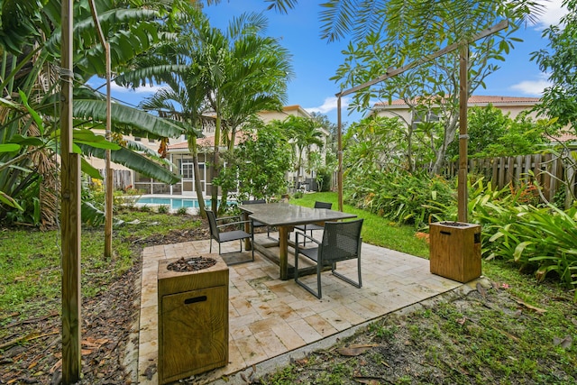 view of patio with fence, an outdoor pool, a fire pit, and outdoor dining space