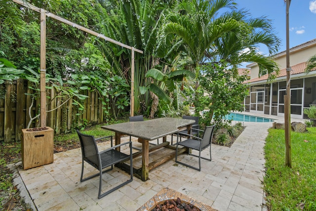 view of patio / terrace with a sunroom and an outdoor fire pit