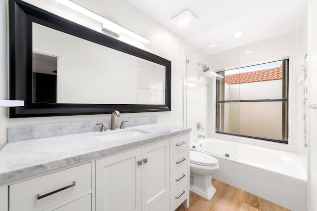 full bathroom featuring toilet, shower / bath combination with glass door, wood-type flooring, and vanity