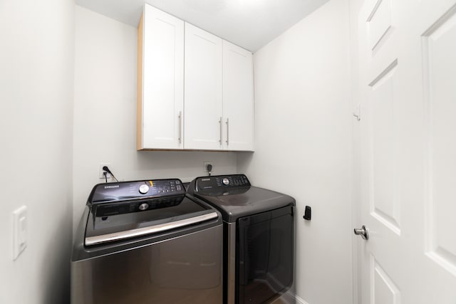 clothes washing area featuring cabinets and independent washer and dryer