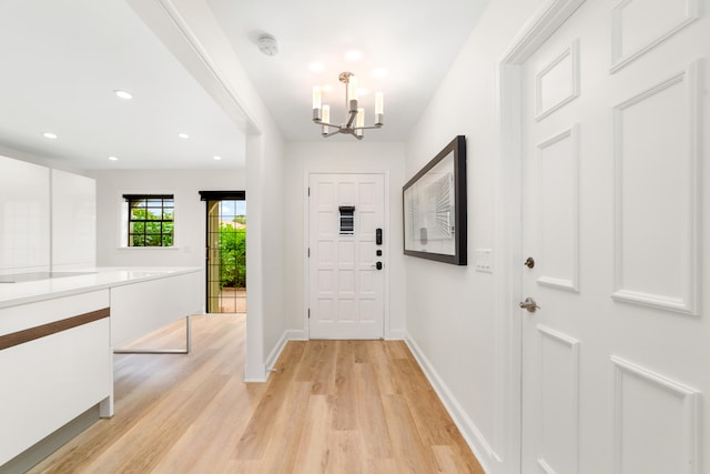 entryway with light wood-type flooring and a notable chandelier