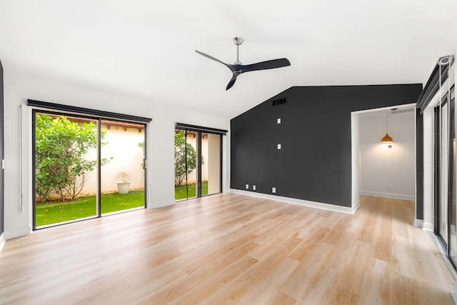 unfurnished living room with light hardwood / wood-style floors, vaulted ceiling, a wealth of natural light, and ceiling fan