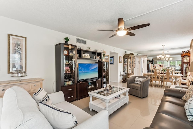 living room featuring a textured ceiling and ceiling fan with notable chandelier