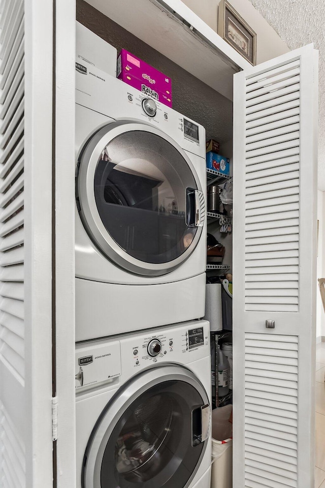 laundry room featuring stacked washer / drying machine