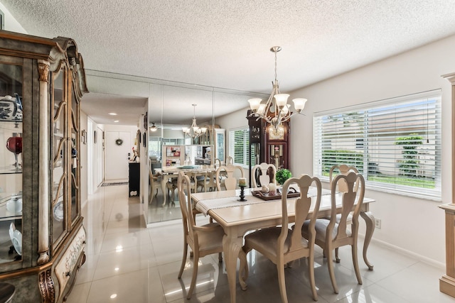 tiled dining room with a chandelier and a textured ceiling