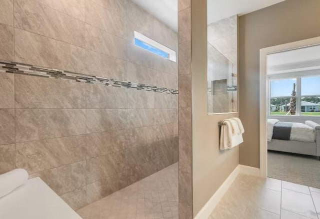 ensuite bathroom with plenty of natural light, baseboards, a walk in shower, and ensuite bathroom