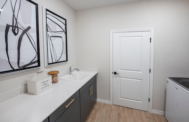 bathroom featuring wood finished floors, vanity, and baseboards