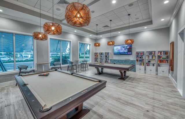 rec room with a high ceiling, wood finished floors, billiards, ornamental molding, and a raised ceiling