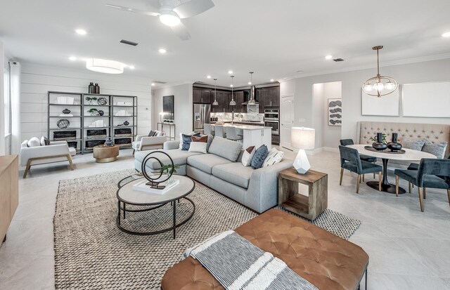 living room with ornamental molding, recessed lighting, and visible vents