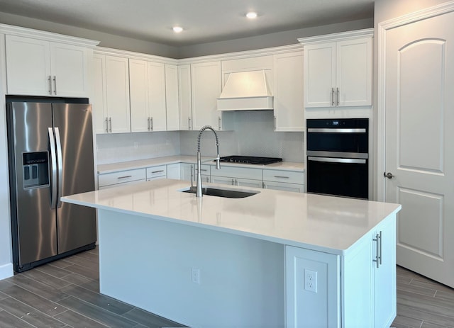 kitchen featuring wood tiled floor, custom range hood, a sink, and black appliances