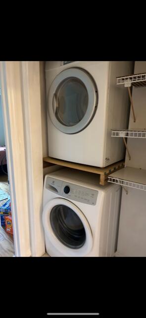 washroom with stacked washing maching and dryer