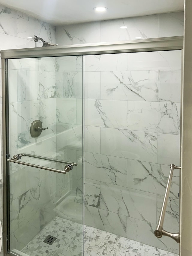 bathroom featuring a shower with shower door