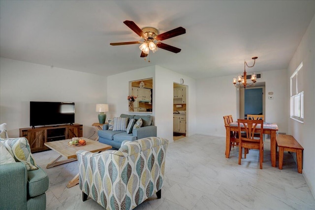 living room featuring ceiling fan with notable chandelier